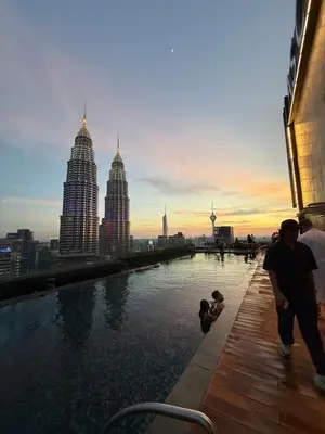 a group of people walking around a pool with a city skyline at Star Residance KLCC by Nexus 84 in Kuala Lumpur