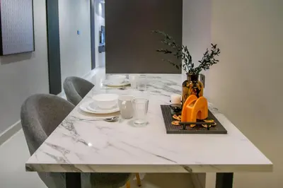 a white marble table with chairs and a vase on it at NOVO Ampang Stylish Studio & 1BR with Infinity Pool near KLCC & Gleneagles in Kuala Lumpur