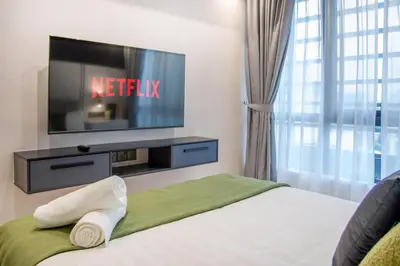 a hotel room with a tv and a bed at NOVO Ampang Stylish Studio & 1BR with Infinity Pool near KLCC & Gleneagles in Kuala Lumpur