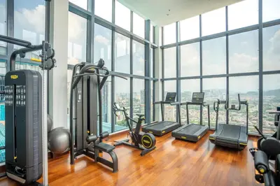 a gym with a lot of exercise equipment and windows at NOVO Ampang Stylish Studio & 1BR with Infinity Pool near KLCC & Gleneagles in Kuala Lumpur