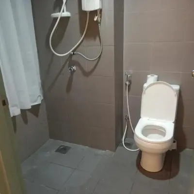 a bathroom with a white toilet in a stall at summer suites studios in Kuala Lumpur