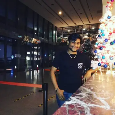 a man standing in front of a christmas tree at summer suites studios in Kuala Lumpur