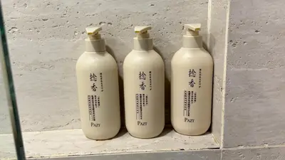 a group of four white bottles sitting on a shelf at Star Residences KLCC by Nexus 62 in Kuala Lumpur