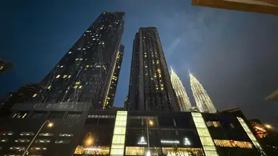 two tall skyscrapers in a city at night at Star Residences KLCC by Nexus 62 in Kuala Lumpur
