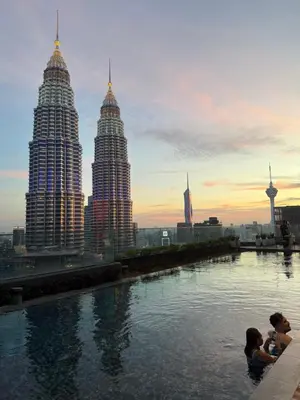 a group of people swimming in a pool with tall buildings at Star Residences KLCC by Nexus 62 in Kuala Lumpur
