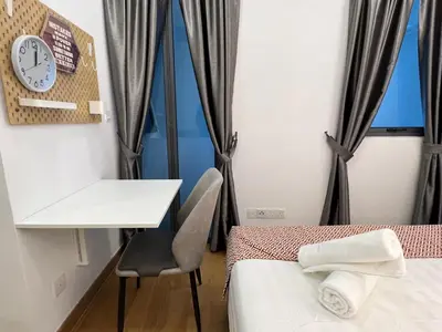 a room with two beds and a desk and a table at THE COLONY BY INFINITUM by ZENTRIP in Kuala Lumpur