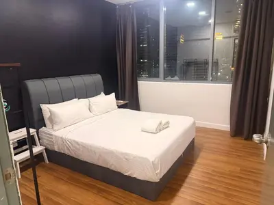 a bedroom with a bed with white sheets and a window at Summer popular suites kl Bukit Bintang in Kuala Lumpur