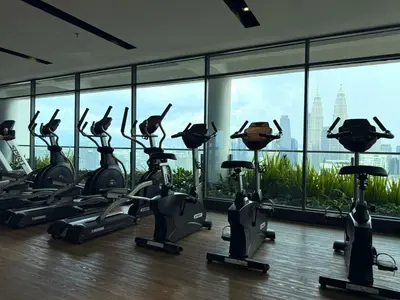a gym with cardio machines in front of a large window at Lucky Suites KLCC By LUXE Infinitum in Kuala Lumpur
