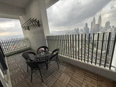 a balcony with a table and chairs on a balcony at Lucky Suites KLCC By LUXE Infinitum in Kuala Lumpur