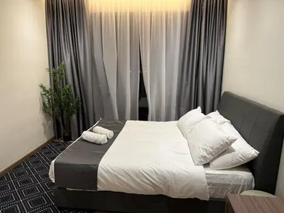 a bedroom with a bed with white sheets and pillows at Alaxis Suite Home By Residensi Brickfields in Kuala Lumpur