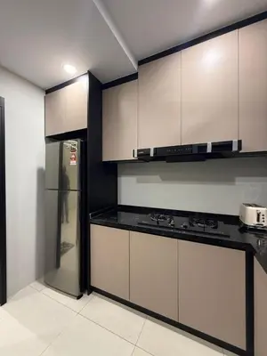 a kitchen with white cabinets and a refrigerator at Alaxis Suite Home By Residensi Brickfields in Kuala Lumpur
