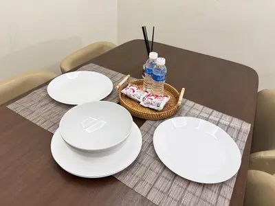 a table with white plates and water bottles on it at Dorsett Hartamas, KL City, Bathtub, Rooftop Pool in Kuala Lumpur