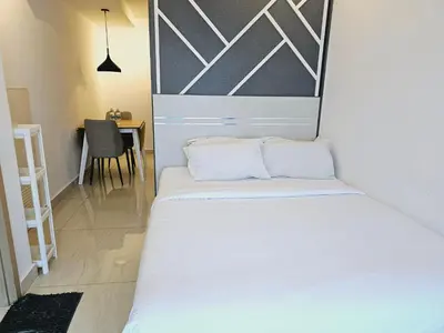 a small bedroom with a white bed and a table at Colony Infinitum KualaLumpur by FR in Kuala Lumpur