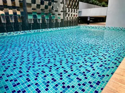 a swimming pool with blue tiles in a building at Neu Suites #2BR Apartment by LammyNora in Kuala Lumpur