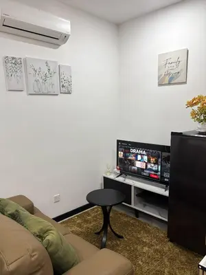 a living room with a couch and a television at Neu Suites #2BR Apartment by LammyNora in Kuala Lumpur