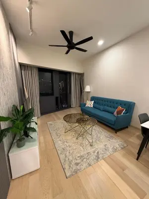 a living room with a blue couch and a ceiling fan at KL Star Residences By Nexus Nest 25 in Kuala Lumpur