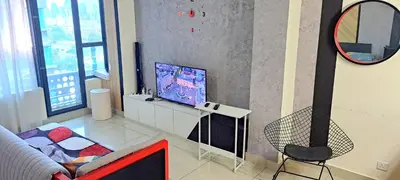 a living room with a tv and a chair at Arte Plus KLCC Family Studio Apartment Kuala Lumpur in Kuala Lumpur