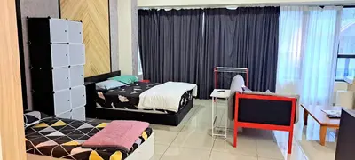 a bedroom with two beds and a table and a desk at Arte Plus KLCC Family Studio Apartment Kuala Lumpur in Kuala Lumpur