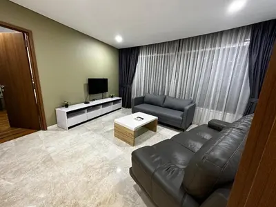 a living room with a leather couch and a television at Vortex suites Klcc by stuning vibes in Kuala Lumpur