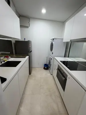 a small kitchen with white cabinets and appliances at Vortex suites Klcc by stuning vibes in Kuala Lumpur