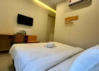 a hotel room with two beds and a television at Swing & Pillows - Imbi Bukit Bintang in Kuala Lumpur