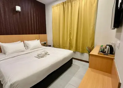 a bedroom with a large bed with a yellow curtain at Swing & Pillows - Imbi Bukit Bintang in Kuala Lumpur