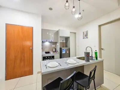 a kitchen with a island with chairs and a counter top at Trion KL by CityNest in Kuala Lumpur