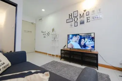 a living room with a flat screen tv and a couch at NEW 2BR KL Gateway LRT Midvalley and KLCC, KL Sentral in Kuala Lumpur