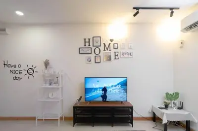 a living room with a flat screen tv on a white wall at NEW 2BR KL Gateway LRT Midvalley and KLCC, KL Sentral in Kuala Lumpur