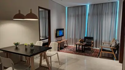 a living room with a table and chairs and a television at Sky Suites KLCC By Stay Happy in Kuala Lumpur