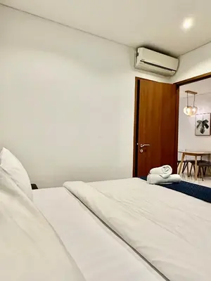 a bedroom with two white beds and a wooden door at Sky Suites KLCC By Stay Happy in Kuala Lumpur