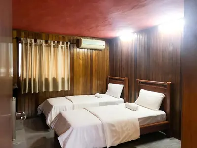 two beds in a room with wooden walls at HOTEL I VILLA INN Bukit Bintang KL in Kuala Lumpur