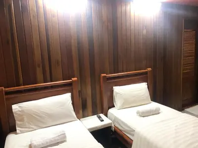 two beds in a room with wooden walls at HOTEL I VILLA INN Bukit Bintang KL in Kuala Lumpur