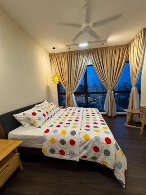 a bedroom with a bed with a polka dot bedspread at Arte Mont Kiara by Skyline in Kuala Lumpur