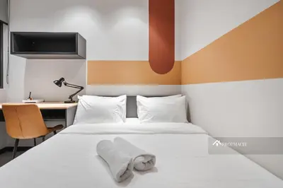 a bedroom with a bed with two white towels on it at Neu Suites By Propmach in Kuala Lumpur