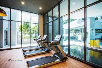 a row of treadmills in a gym with windows at Neu Suites By Propmach in Kuala Lumpur