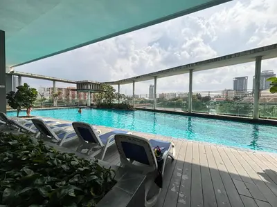 a large swimming pool with chairs in a building at Casa Residency Bukit Bintang by PILLOWTALKS in Kuala Lumpur