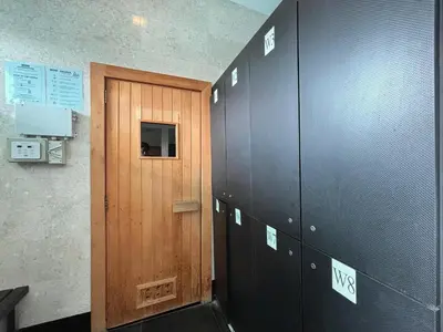 a locker room with a wooden door and some lockers at Casa Residency Bukit Bintang by PILLOWTALKS in Kuala Lumpur