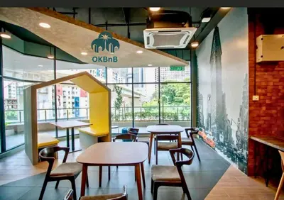 a restaurant with tables and chairs in a building at Neu Suites by OKBnB in Kuala Lumpur