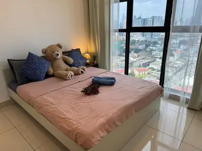 a teddy bear sitting on top of a bed at Trion KL TRX KLCC 6 Pax in Kuala Lumpur