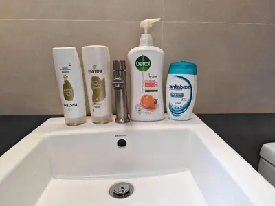 a bathroom sink with products on top of it at Urban Designer's Duplex in Ampang