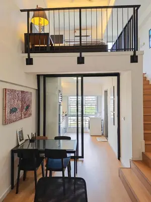 a dining room with a table and chairs and a staircase at Urban Designer's Duplex in Ampang