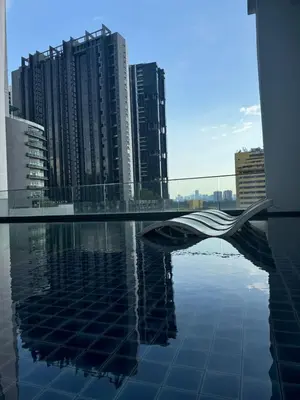 a bridge over water in a city with tall buildings at KLCC View Suites By Reizz Residence in Kuala Lumpur