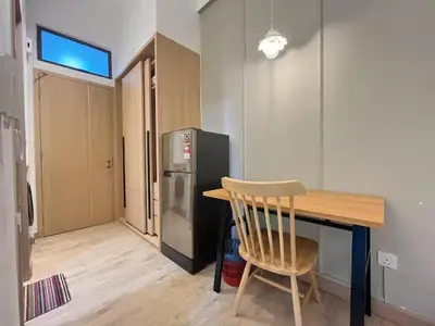 a kitchen with a wooden table and a refrigerator at The Colony By Infinitum Q in Kuala Lumpur
