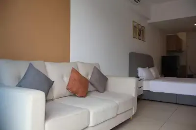 a living room with a white couch and a bed at The Colony By Infinitum B in Kuala Lumpur