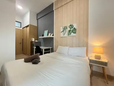 a bedroom with a large white bed and a desk at The Colony By Infinitum G in Kuala Lumpur