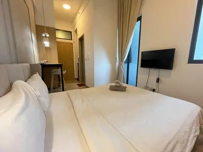 a bedroom with a white bed and a television at The Colony By Infinitum R in Kuala Lumpur