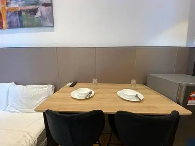 a wooden table with two chairs and plates on it at The Colony By Infinitum T in Kuala Lumpur