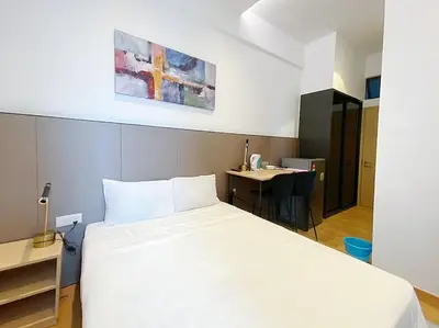 a bedroom with a large white bed and a desk at The Colony By Infinitum T in Kuala Lumpur