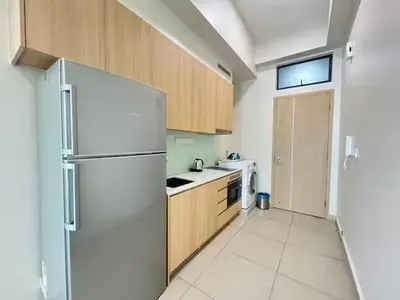 a kitchen with a white refrigerator and wooden cabinets at The Colony By Infinitum F in Kuala Lumpur